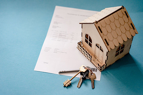 House miniature with keys with paper underneath photo
